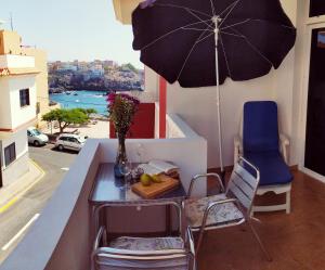 a table and chairs with an umbrella on a balcony at Casa Atlantica in Alcalá