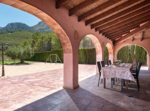 an outdoor patio with a table and chairs under an archway at Villa Vinyent - Plusholidays in Calpe
