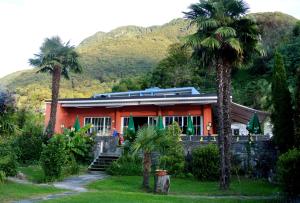 an orange house with palm trees in front of it at La Riva in Vira