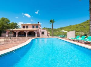 a swimming pool with chairs and a house at Villa Vinyent - Plusholidays in Calpe