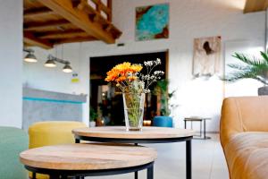 a vase of flowers on a table in a room at Hotel Restaurant Fronmühle in Bad Dürkheim