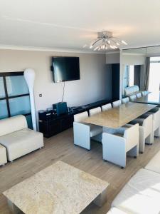 salon ze stołem, krzesłami i telewizorem w obiekcie "München" - Very Spacious Family Apartment with Seaview w Ostendzie