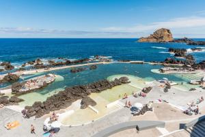 a pool at a resort with people in the water at Aqua Natura Bay in Porto Moniz