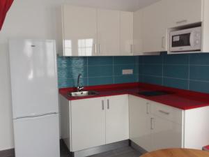 a white kitchen with a sink and a refrigerator at Atlantis Las Lomas in Puerto del Carmen