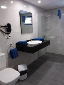 een badkamer met een wastafel, een toilet en een spiegel bij Atlantis Las Lomas in Puerto del Carmen