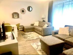 a living room with a couch and a table at Apartamentul Verde Silver Mountain Poiana Brașov in Poiana Brasov