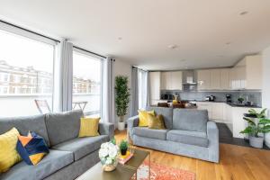 uma sala de estar com dois sofás e uma cozinha em homely – Central London Luxury Apartments Camden em Londres