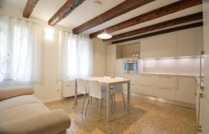 a kitchen with a table and chairs in a room at Dimora Frari, vicino Campo Santa Margherita in Venice