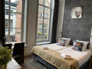 a bedroom with two beds and a window at Hotel de Prince in Nijmegen