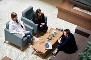 un grupo de personas sentadas alrededor de una mesa de café en Ramada by Wyndham Podgorica, en Podgorica