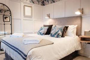 a bedroom with a white bedspread and pillows at Head of the River in Oxford
