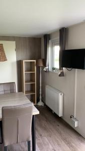Zimmer mit einem Bett, einem TV und einem Tisch in der Unterkunft Luxe Chalet dichtbij Zoutelande in Biggekerke