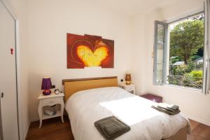 a bedroom with a bed with a heart painting on the wall at Casa Julia in Menaggio