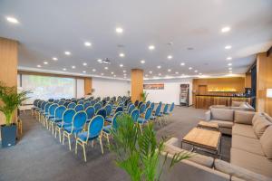 a conference room with blue chairs and couches at Karpatski Hotel & Spa in Bukovel