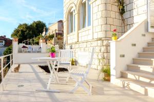 una mesa blanca y 2 sillas en el patio en Apartments Dubrovnik Seven, en Dubrovnik