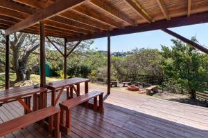 eine Holzterrasse mit Bänken und Aussicht in der Unterkunft Barefoot B&B in Morganʼs Bay