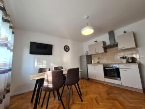 a kitchen with a table and chairs in a room at Boutique Apartments Nikola Tesla in Rakovica