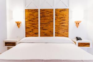 - une chambre blanche avec un lit blanc et 2 tables dans l'établissement Apartamentos Parque del Sol, à Adeje