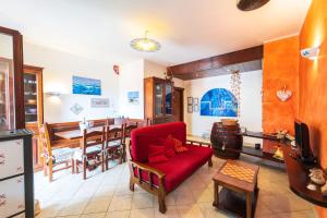 a living room with a red chair and a table at Alghero Amantiosu Casa Vacanze in Alghero