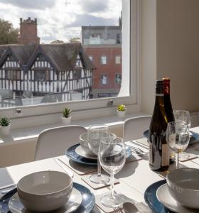 a table with glasses and a bottle of wine and a window at Hereford City Centre - Apartment 5, Isabella House - Modern Apartment In The Heart of The City - Sleeps 6 Guests - Hosted by RENTMYHOUSE in Hereford +6 photos