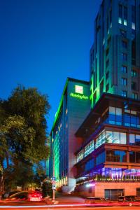 um edifício com um sinal verde no lado em Holiday Inn - Kyiv, an IHG Hotel em Kiev
