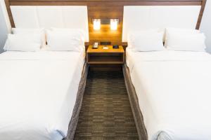 two beds in a hotel room with a table between them at Holiday Inn Express Hollywood Walk of Fame by IHG in Los Angeles