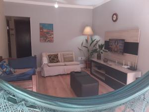 a living room with a couch and a tv at Linda casa Rio das Ostras in Rio das Ostras