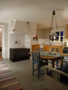 a dining room and kitchen with a table and chairs at Röda stugan in Hedemora