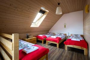 a room with three beds in a wooden cabin at Apartamenty Stara Morawa - Zew Natury in Stronie Śląskie