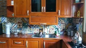 a kitchen with wooden cabinets and a sink at Villa Joglo Cimande in Bogor