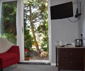 un soggiorno con una grande finestra e una TV di Middle Farm Villa B&B a Wellingborough