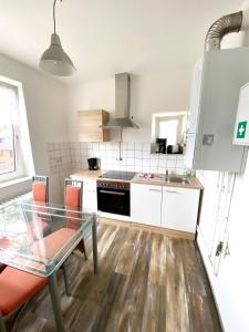 a kitchen with a glass table and a stove top oven at Ruhige 3-Zimmerwohnung im Norden Bremens für Monteure und Geschäftsreisende in Bremen