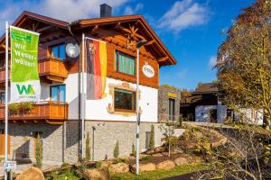 uma casa com bandeiras em frente em Steig-Alm Hotel Superior em Bad Marienberg