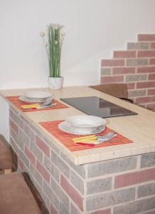 a brick table with plates and utensils on it at Apartment Forteca Lux in Perast