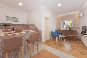 a kitchen and living room with a brick wall at Apartment Forteca Lux in Perast