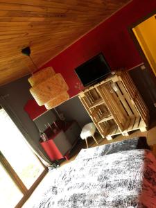 een slaapkamer met een bed en een flatscreen-tv bij Une Escapade sur La Palette in Bertogne