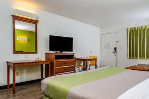 a hotel room with a bed and a flat screen tv at Motel 6 Oakdale, Ca in Oakdale