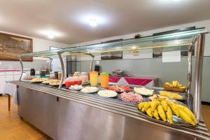 a buffet line with many different types of food at Hotel Esplanada Belo Horizonte - Proximo a Estacao de Trem in Belo Horizonte