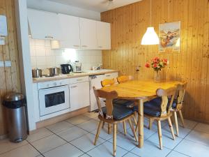a kitchen with a wooden table and chairs in it at Les Fledd's in La Chapelle-dʼAbondance