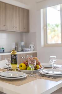 einen Tisch mit zwei Gläsern Wein und eine Schale Obst in der Unterkunft Argiri Apartments & Suites in Georgioupoli