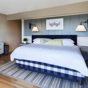 a bedroom with a large bed with two lights on it at Cliff House Maine in Cape Neddick
