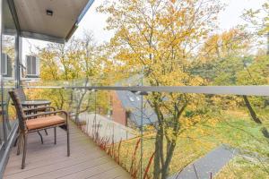 a balcony with a bench and a view of trees at Palanga Apartments Near Baltic Sea in Palanga