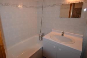 a white bathroom with a sink and a bath tub at VAUJANYLOCATIONS - Cochette II Apt 1 & 2 in Vaujany