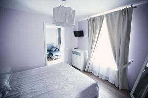 ein weißes Schlafzimmer mit einem Bett und einem Fenster in der Unterkunft ANDRIAUS APARTAMENTAI in Palanga