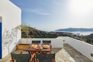 キモロスにあるAria Kimolos Residenceのテーブルと椅子、海の景色を望むバルコニー