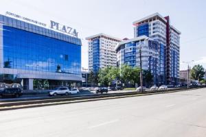 a city street with cars parked in front of tall buildings at Apartment Romantic Никитина 107 in Barnaul