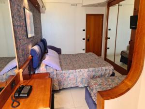 Pokój hotelowy z 2 łóżkami i lustrem w obiekcie Hotel Sabra w mieście Senigallia