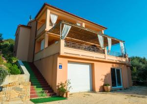 ein Haus mit einem Tor und einer Garage in der Unterkunft Apartments Villa Kristina in Supetarska Draga