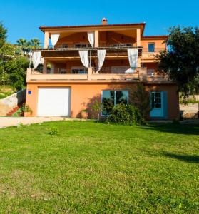 a house with a lawn in front of it at Apartments Villa Kristina in Supetarska Draga