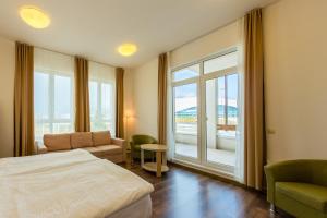a hotel room with a bed and a window at Apart Hotel Imeretinskiy - Morskoy Kvartal in Adler